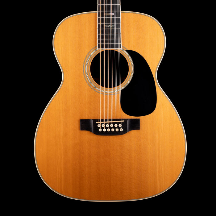Acoustic guitar with a natural wood finish on a black background