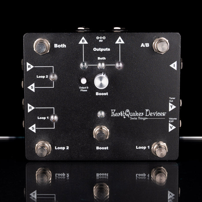 Black electronic pedal with labeled components on a black background
