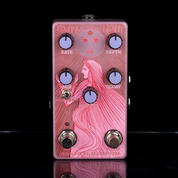Guitar effects pedal with artistic design on a black background