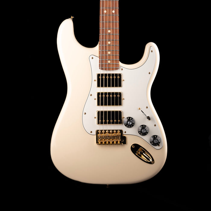 White electric guitar with a black pickguard on a white background
