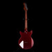 Guitar with a maroon body and white pickguard on a black background