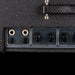 Close-up of a guitar amplifier with control knobs and jacks on a black background
