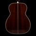 Back view of a wooden acoustic guitar on a black background