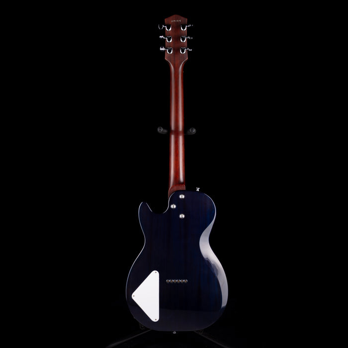 Black electric guitar with a white pickguard on a black background
