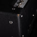 Close-up of a black guitar amplifier with visible screws and text.