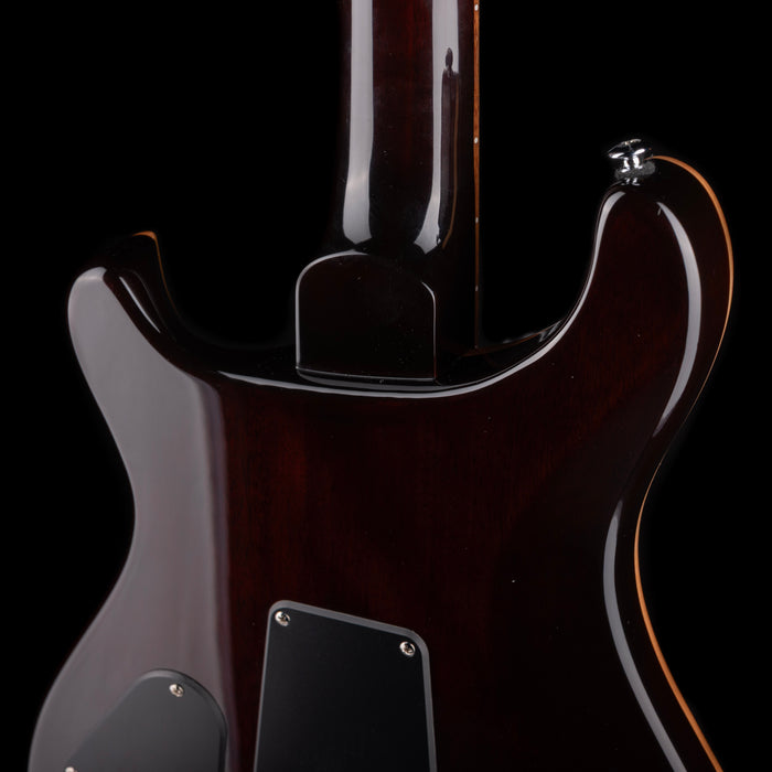 Close-up of a guitar's neck and headstock on a black background
