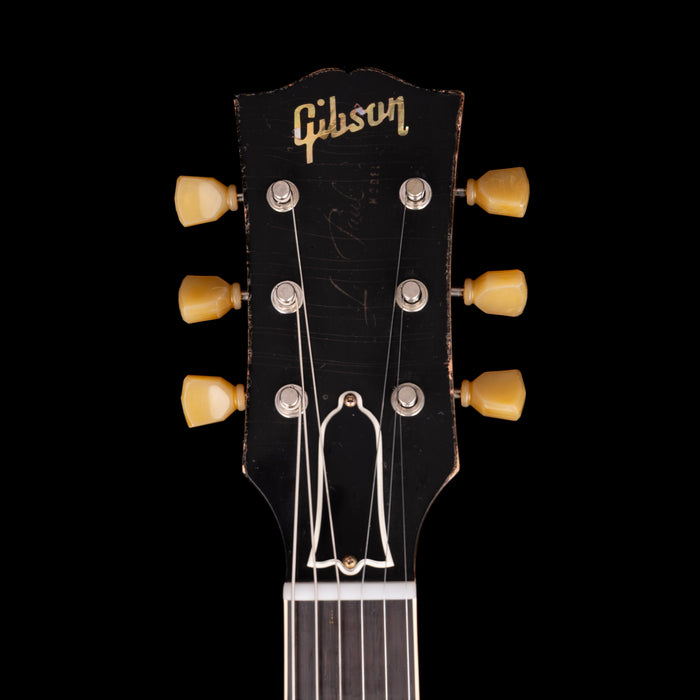 Gibson guitar headstock with tuning pegs on a black background