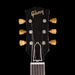Gibson guitar headstock with tuning pegs on a black background