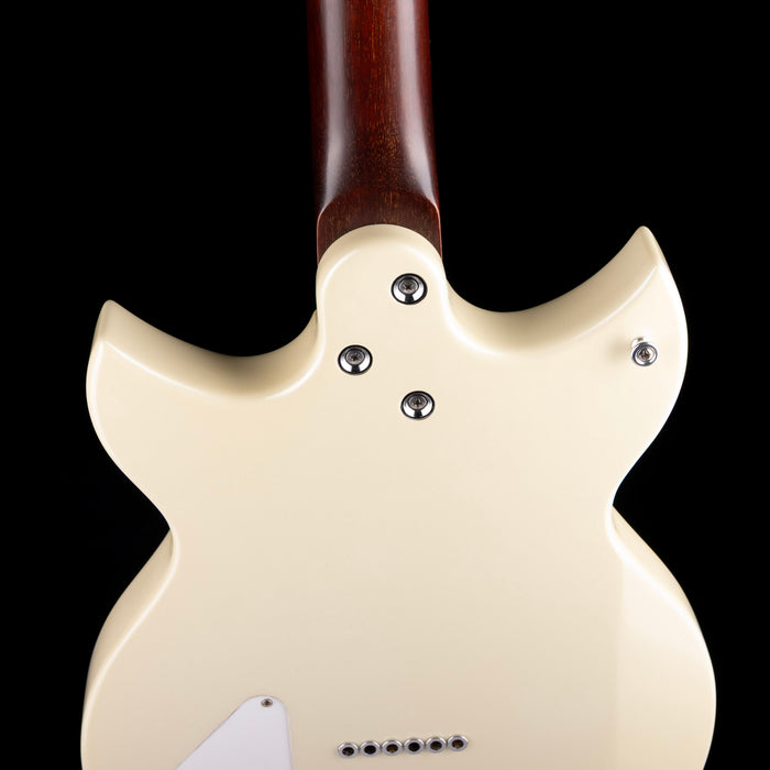 Close-up of a cream-colored electric guitar body with a dark background