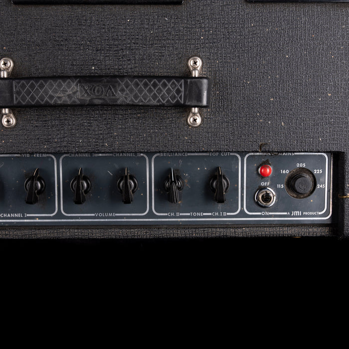 Close-up of a guitar amplifier with control knobs and labels.
