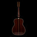 Wooden acoustic guitar on a stand with a black background