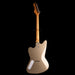 Electric guitar with a beige body and wooden neck on a black background