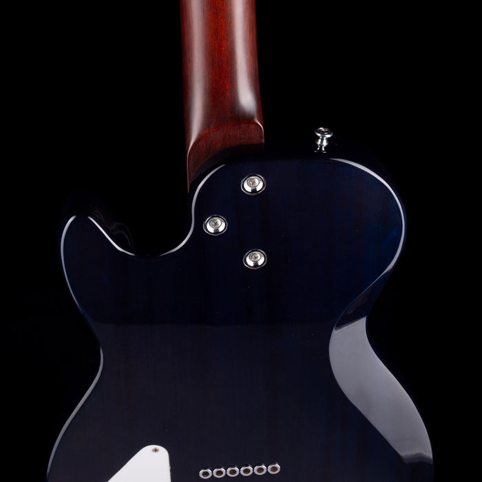 Close-up of a black electric guitar with a wooden neck on a black background
