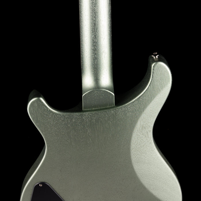 Close-up of a metallic guitar neck and body on a black background