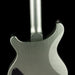 Close-up of a metallic guitar neck and body on a black background