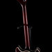 Close-up of a guitar neck and headstock on a black background