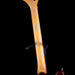 Close-up of a wooden guitar neck on a black background