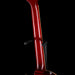 Close-up of a red electric guitar neck on a black background