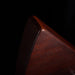 Close-up of a brown leather wallet corner on a dark background