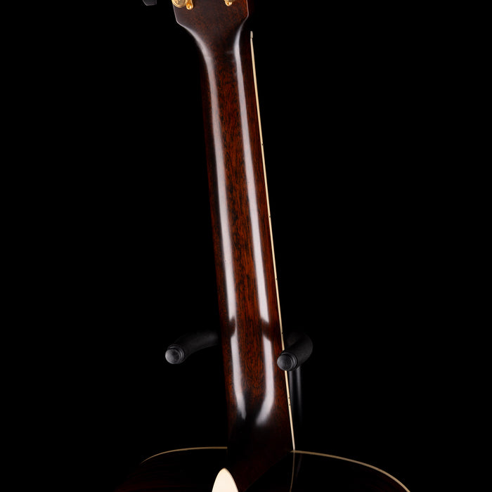 Close-up of a guitar neck with a dark finish on a black background