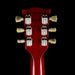 Close-up of a red guitar headstock with tuning pegs on a black background