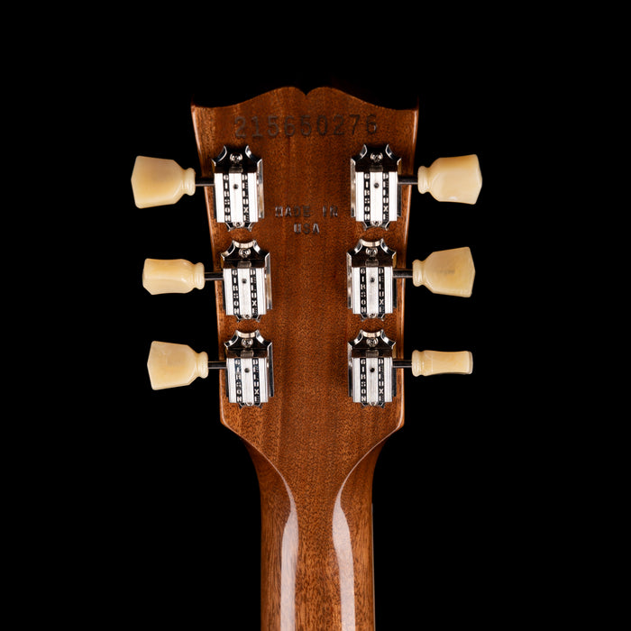 Close-up of a guitar headstock with tuning pegs on a black background