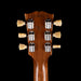 Close-up of a guitar headstock with tuning pegs on a black background