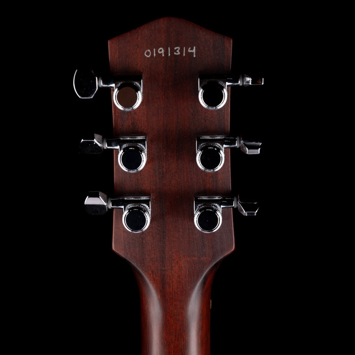 Close-up of a guitar headstock with tuning pegs on a black background