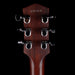 Close-up of a guitar headstock with tuning pegs on a black background