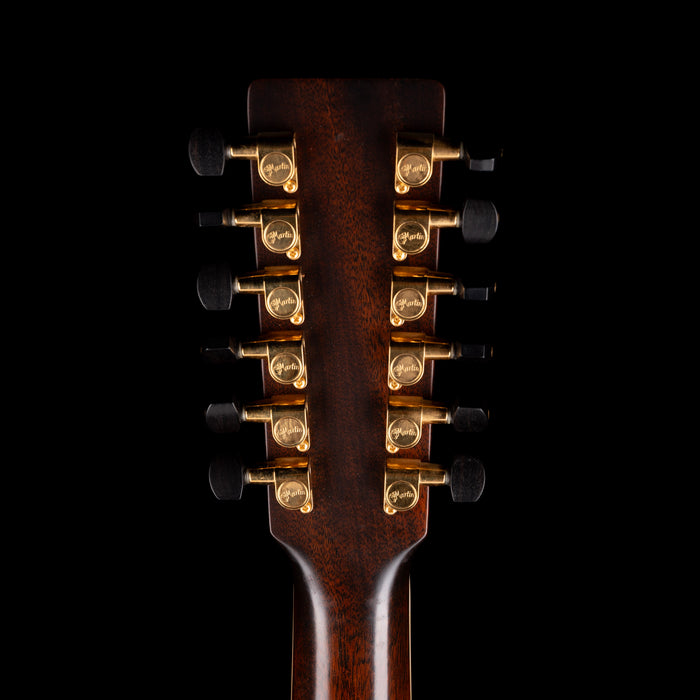 Close-up of a guitar's headstock with tuning pegs on a black background