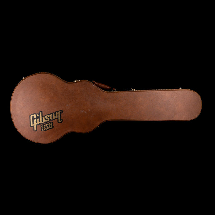 Brown Gibson guitar case on a black background