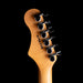 Close-up of a guitar headstock with tuning pegs on a black background