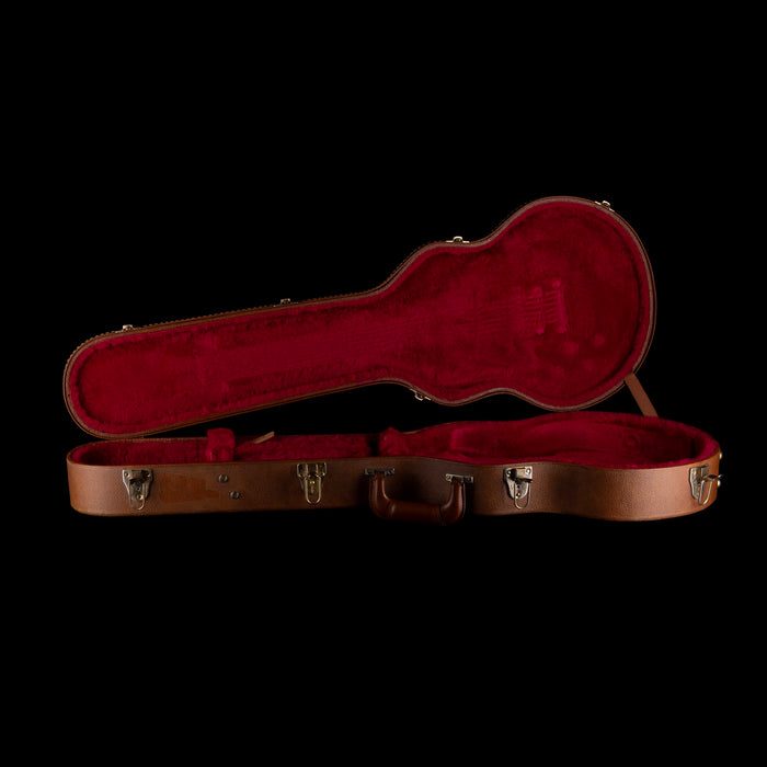Open guitar case with red interior on a black background