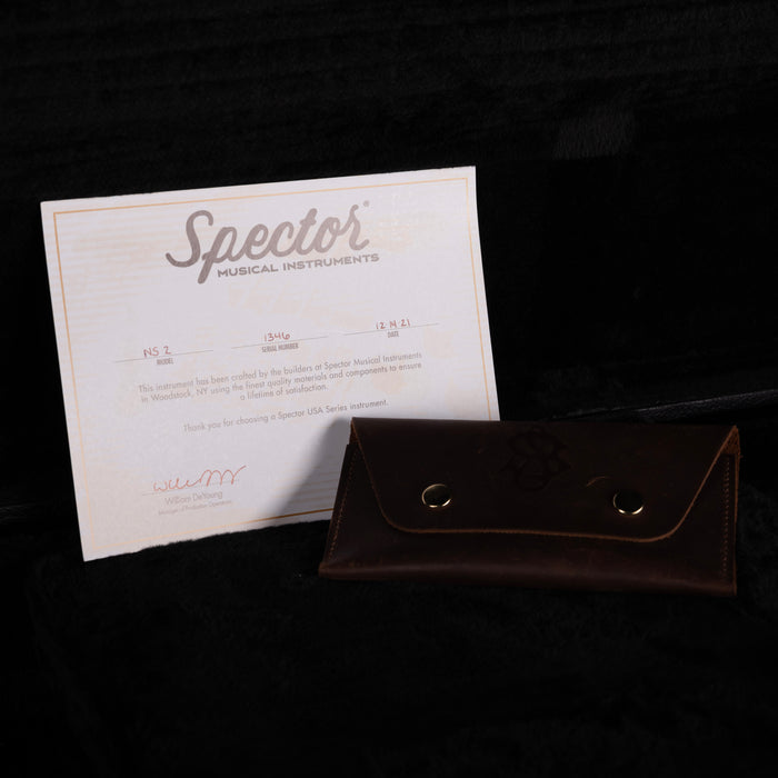 Spector musical instruments certificate and brown leather case on a dark background