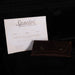 Spector musical instruments certificate and brown leather case on a dark background
