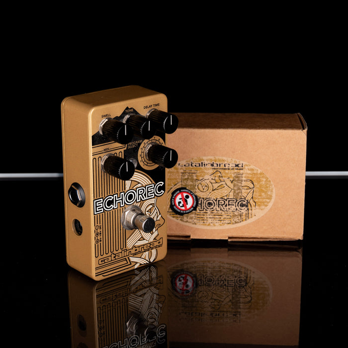 Guitar effects pedal with 'Echorec' branding next to its packaging on a reflective surface.