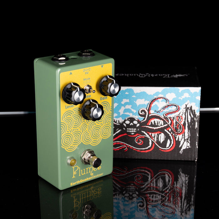 Green and yellow guitar effects pedal with a decorative box in the background