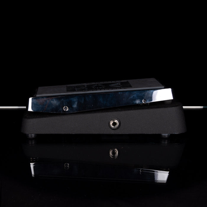 Guitar effects pedal with a dark finish on a reflective surface