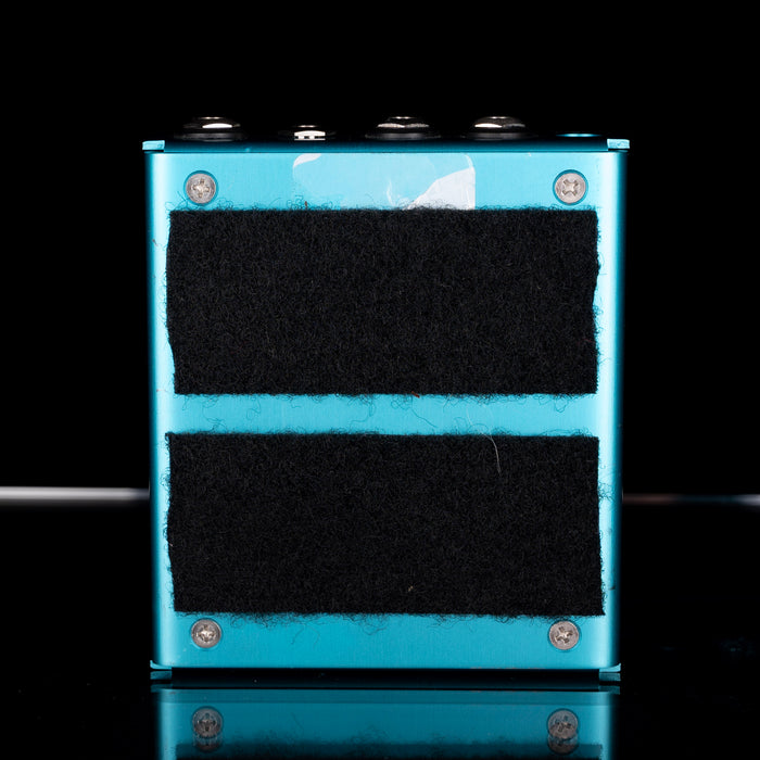 Blue rectangular object with black foam pads on a reflective surface