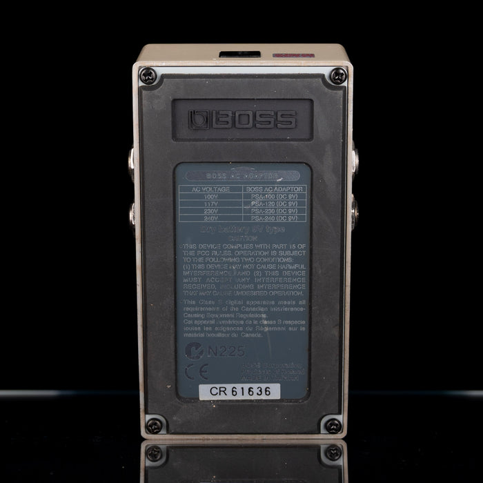 Back view of a Boss digital delay effects pedal on a black background