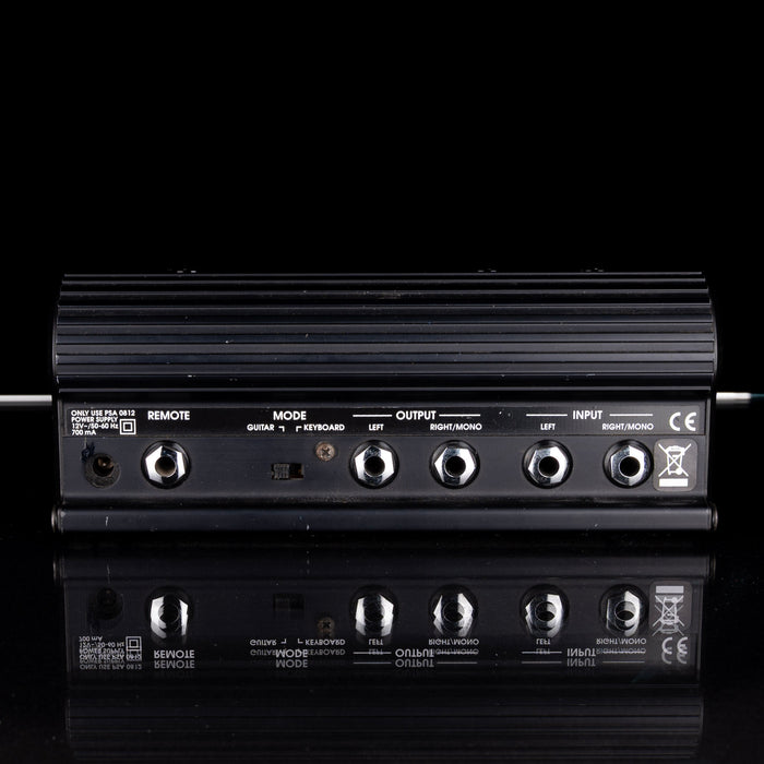 Black audio amplifier with various input and output ports on a black background