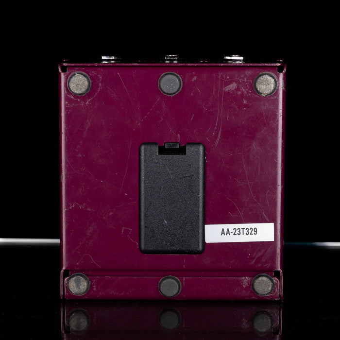 Purple electrical switch with a black rocker switch on a black background
