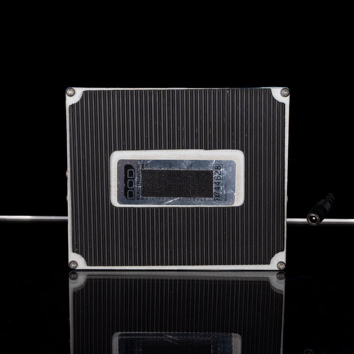 Black and silver electronic device on a reflective surface with a black background