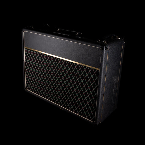 Black guitar amplifier with grille on a black background