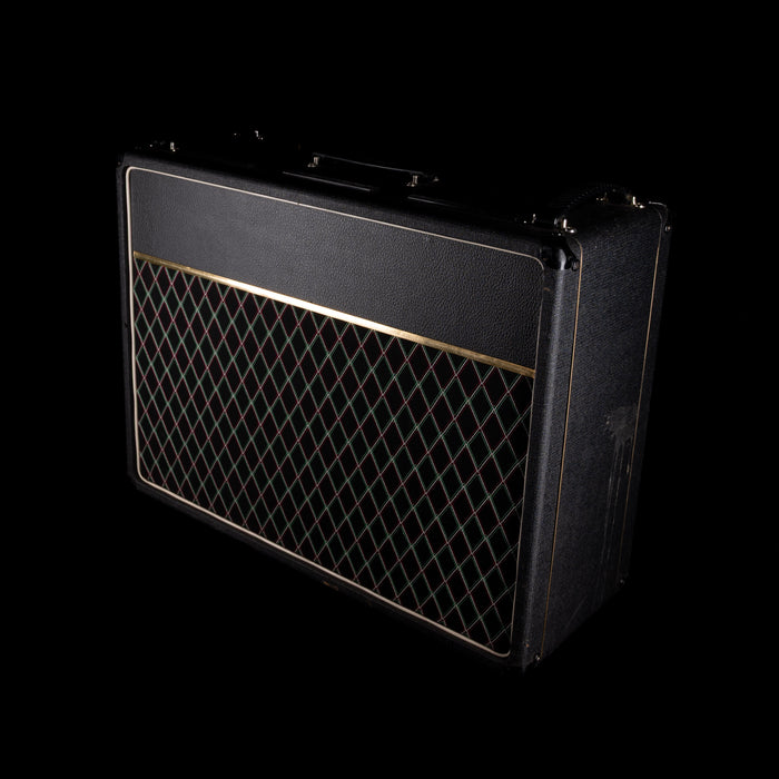 Black guitar amplifier with grille on a black background