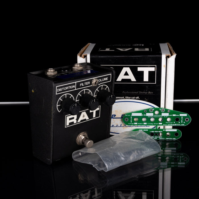 Guitar effects pedal with 'RAT' branding on a reflective surface.