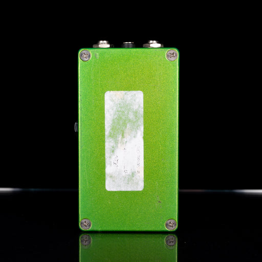 Green guitar effects pedal with a white label on a black background