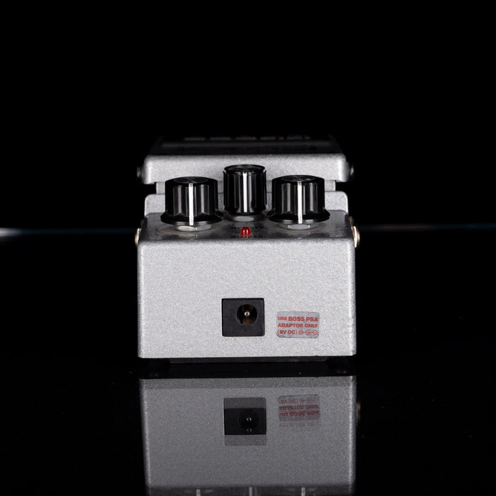 Guitar effects pedal with three knobs on a black background