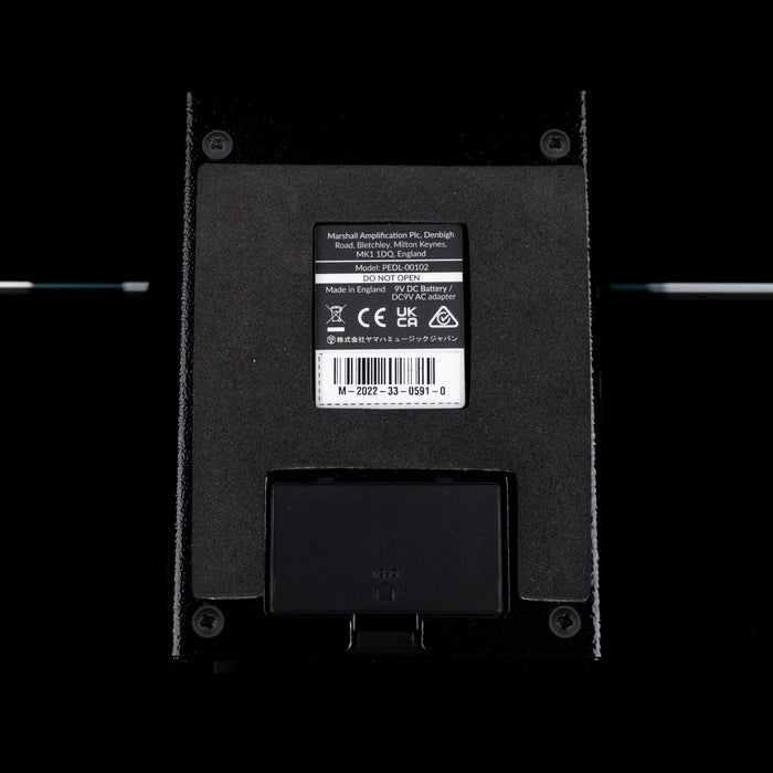 Back view of a black electronic device with a label on a white background