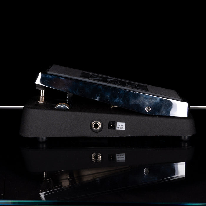 Guitar pedal with blue and black design on a reflective surface